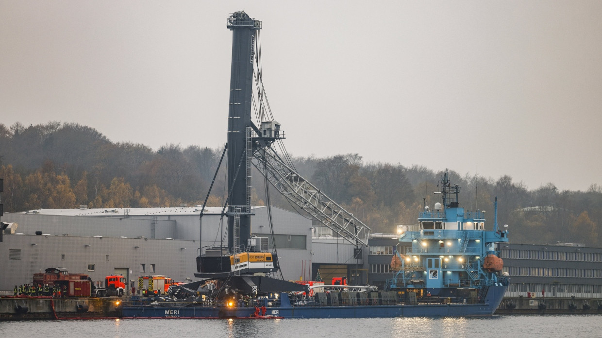 Einsatzkräfte der Feuerwehr arbeiten an der ·Meri·, dem Schiff, dass bei der Durchfahrt der Hochbrücke in Kiel-Holtenau mit der Brücke kollidiert ist.