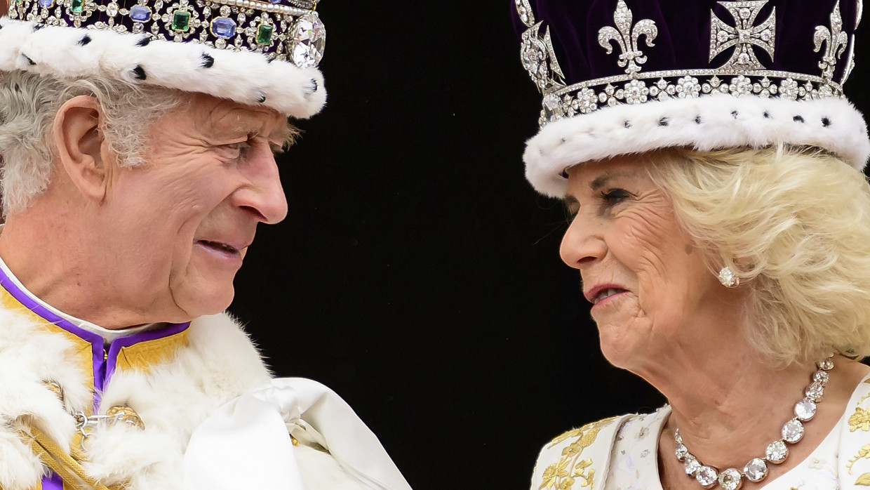 London: König Charles III. und Königin Camilla sehen sich an, als sie nach ihrer Krönung auf dem Balkon des Buckingham-Palastes stehen.