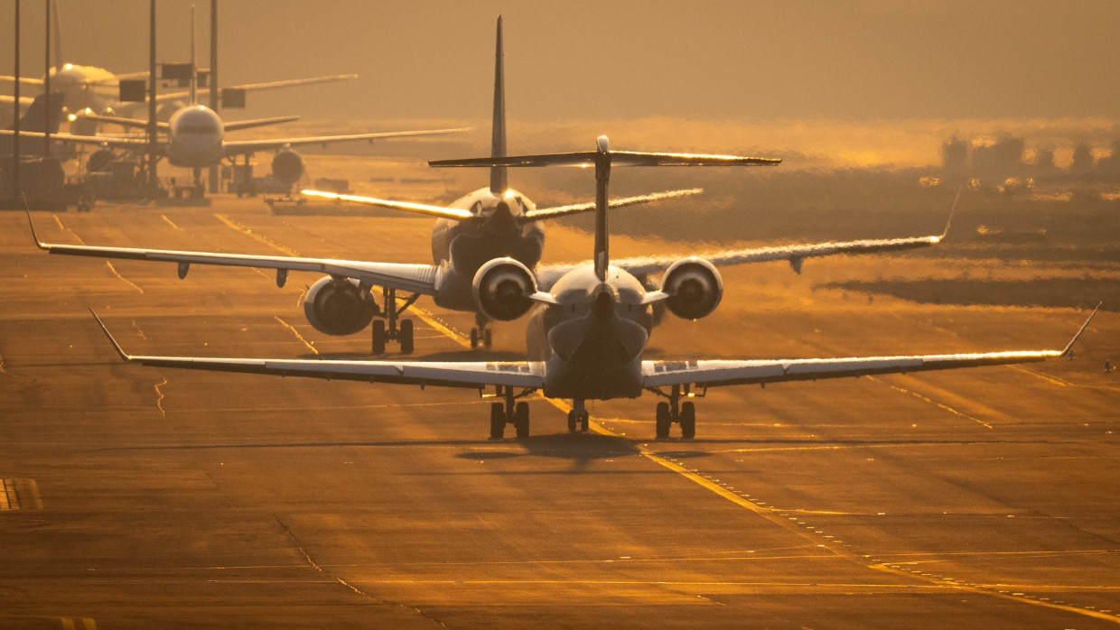 Flugzeuge rollen im Februar 2024 auf dem Flughafen Frankfurt im letzten Sonnenlicht des Tages über die Rollbahn.