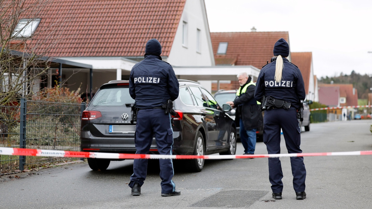 Polizisten stehen vor einem Haus in Weisendorf.