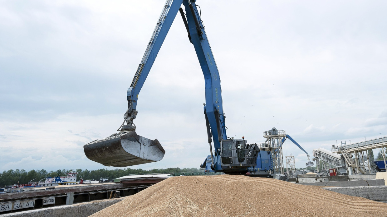 Ukraine, Ismajil: Ein Bagger verlädt in einem Getreidehafen Getreide in ein Frachtschiff.