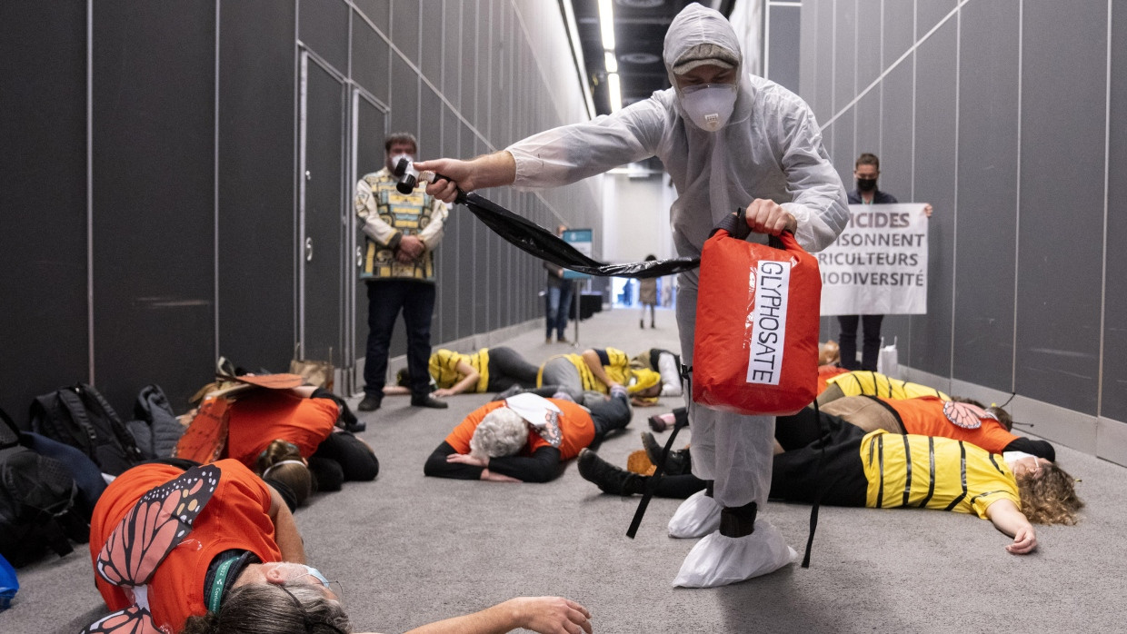 Ein Mitglied des Wildnis-Komitees besprüht im kanadischen Montreal im Dezember 2022 symbolisch als Insekten verkleidete Mitdemonstranten mit dem Herbizid Glyphosat. Ein Protest, der vor einer Konferenz der Agrochemie-Lobbygruppe CropLife im Rahmen des Weltnaturgipfels COP15 stattfand.