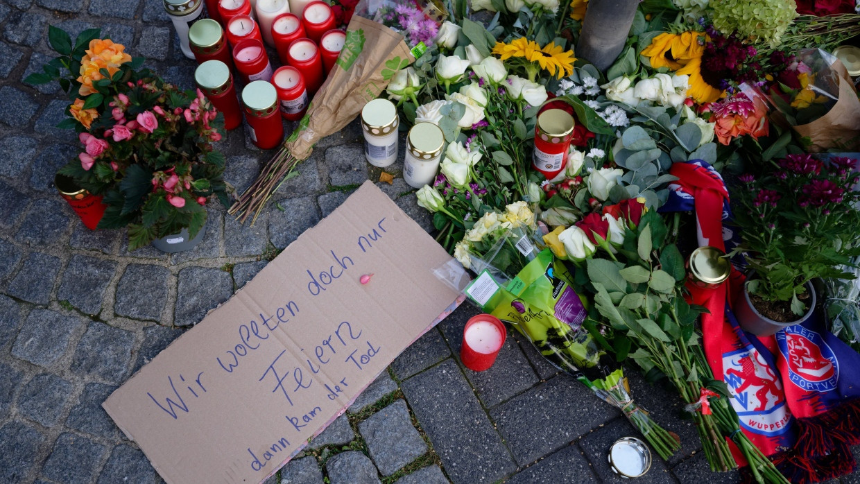 Menschen legen in Solingen in Gedenken an die Opfer der Messerattacke Blumen ab und zünden Kerzen an