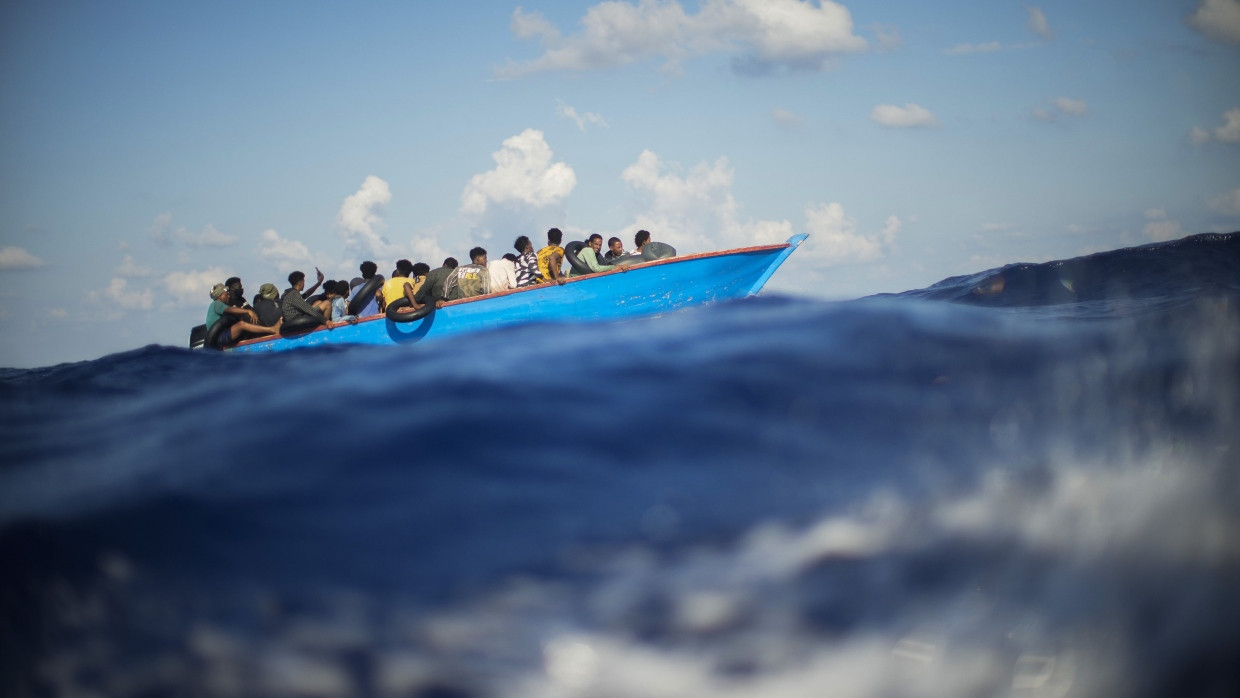 Migranten in einem Holzboot auf dem Mittelmeer (Symbolbild).