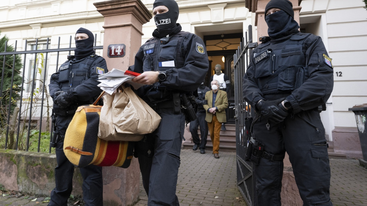 Bei einer Razzia gegen die „Reichsbürger“ führen Polizisten Heinrich XIII. Prinz Reuß (hinten, Mitte) zu einem Polizeifahrzeug.