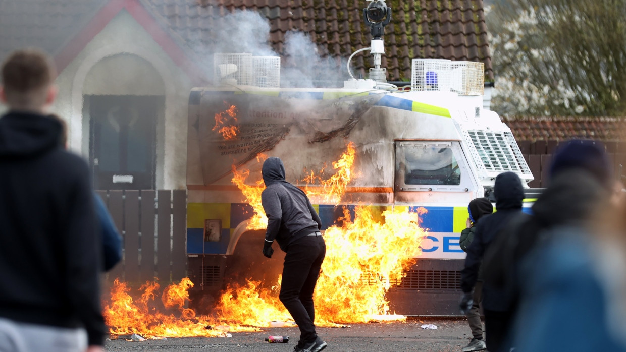 Jugendliche werfen Benzinbomben auf einen Land Rover der Polizei, während republikanische Demonstranten eine Parade abhalten.