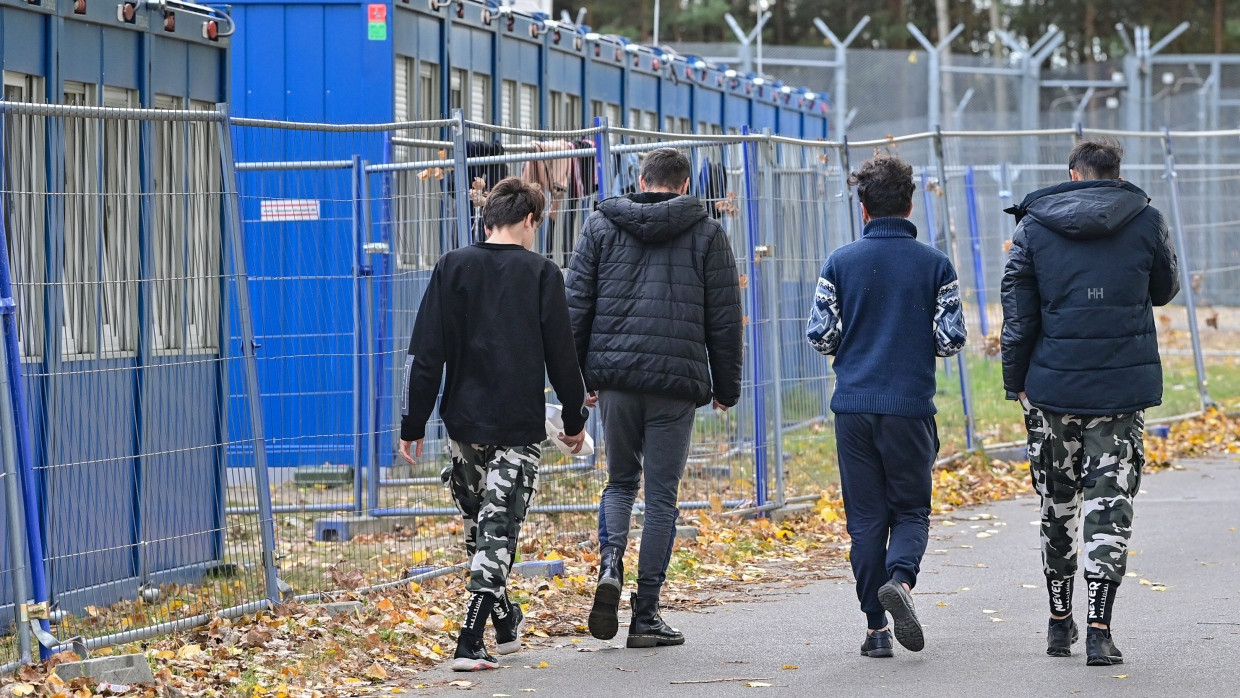 Flüchtlinge gehen über das Gelände der Zentralen Erstaufnahmeeinrichtung für Asylbewerber (ZABH) des Landes Brandenburg.