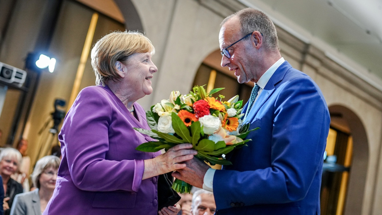 Friedrich Merz, CDU-Bundesvorsitzender, überreicht Angela Merkel einen Blumenstrauß.