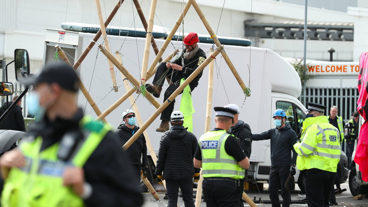 Ein Demonstrant klettert in Broxbourne von einer Bambuskonstruktion, die als Blockade vor einer Druckerei genutzt wurde.