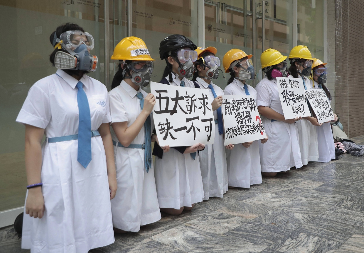 Schülerinnen tragen Gasmasken und Helme bei Protesten im St. Francis' Canossian College in Hongkong.