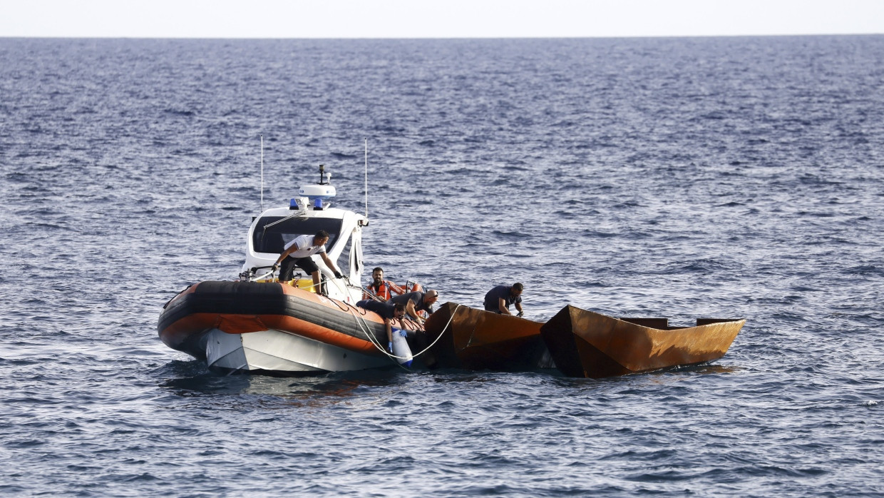 Die italienische Küstenwache schleppt vor Lampedusa ein Boot von Migranten ab