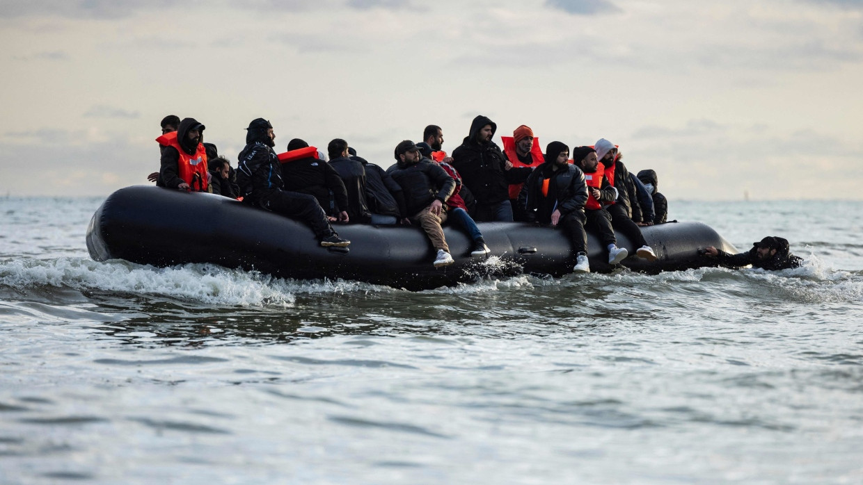 Migranten sitzten auf einem Schlauchboot und versuchen, den Ärmelkanal zu überqueren.