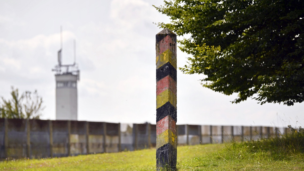 Ein ehemaliger Grenzpfosten steht vor einem Wachturm der DDR-Grenztruppen und einem Grenzzaun in Geisa (Thüringen) an der Landesgrenze zwischen Thüringen und Hessen, aufgenommen am 22.08.2017.