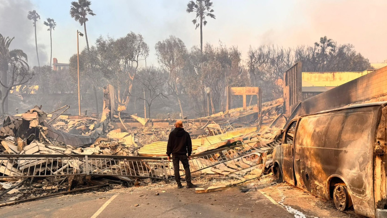 Ein Mann steht vor einem von den Bränden zerstörten Gebäude in Los Angeles.