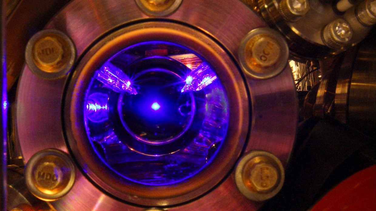 Blick in das Innere einer Strontium-Atomuhr: Strontium-Atome werden von Laserstrahlen in der Schwebe gehalten und erzeugen selbst ein blaues Leuchten.