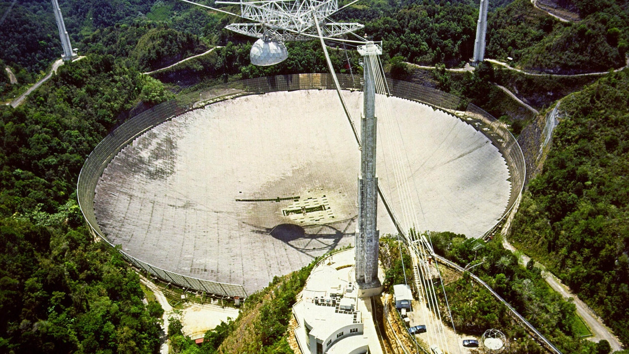 Drei Minuten auf Sendung: Das 305 Meter große Radioteleskop Arecibo Observatory auf Puerto Rico auf einer Aufnahme aus dem Jahr 2006. Nachdem im August und Dezember 2020 mehrere Stahlseile rissen und die Instrumentenplattform in die Schüssel stürzte, existiert es nicht mehr.