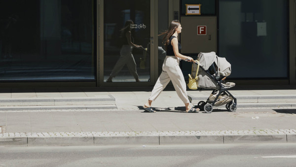 Frau mit Kinderwagen: Was bewirkt das Elterngeld?