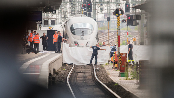 Polizisten und Feuerwehrleute spannen im Frankfurter Hauptbahnhof eine weiße Plane als Sichtschutz vor den ICE, der den achtjährigen Jungen erfasste.