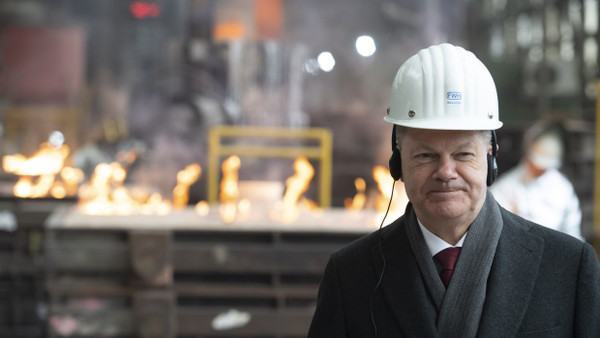 Der Helm sitzt schief: Olaf Scholz zu Besuch in einer Stahlhütte in Mülheim