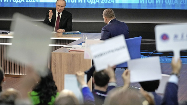 Die Journalisten recken Tafeln in die Höhe: Putins jährliche Pressekonferenz