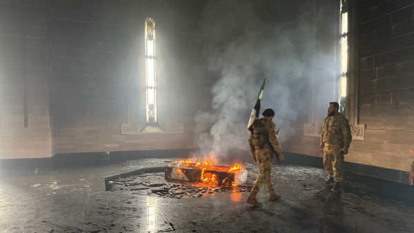 Rebellen stehen am Mittwoch in dem geschändeten Mausoleum des Vaters von al-Assad, dem gestürzten syrischen Diktator.