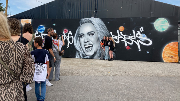 Menschen stehen vor der Selfie-Wand in der Adele World Schlange.