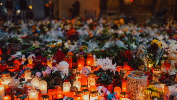 Kerzen und Blumen für die Opfer des Anschlags auf den Magdeburger Weihnachtsmarkt vor der Johanniskirche