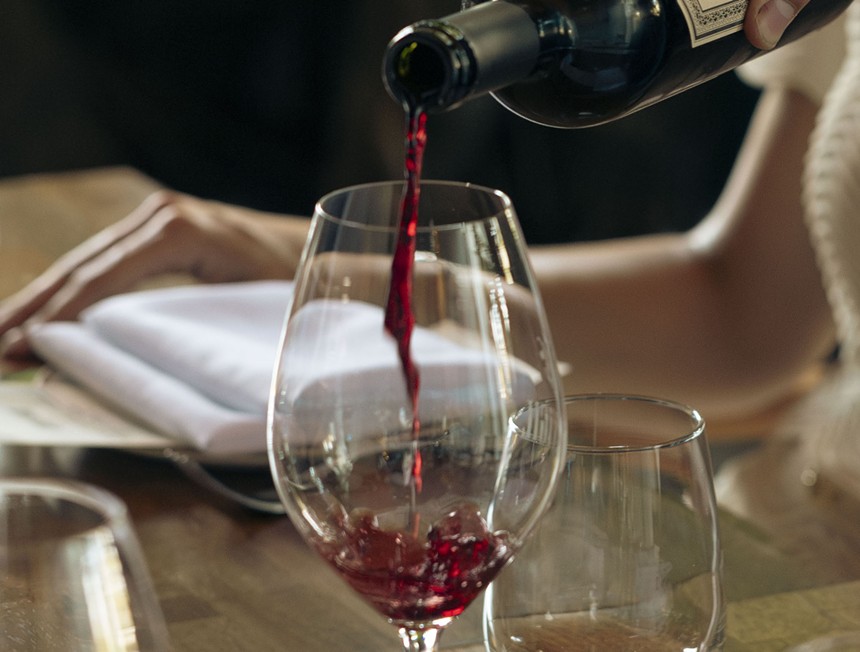 a glass of red wine on a wood table