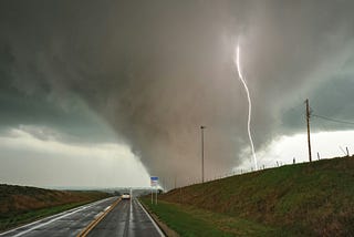 A close-up of a tornado with a lightning bolt from above