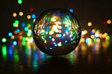 Color lights shine from behind a circular orb or crystal ball