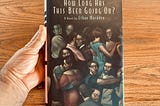 A hand holds a hardcover book, Ethan Mordden’s “How Long Has This Been Going On.” The cover shows men slow dancing with men and women slow dancing with women on a dance floor