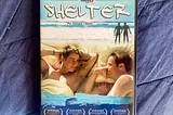 The DVD of the movie Shelter, featuring two men staring at one another while in bed, with an image of two men facing the ocean above them