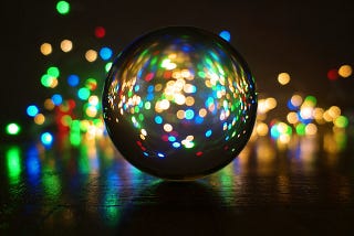 Color lights shine from behind a circular orb or crystal ball