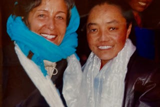 A nun standing with the author outside a rural monastery in Tibet. Both heavily clothed due to high altitude cold.