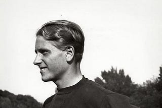 Zdeněk Koubek, standing on a sports field, wearing an athletic shirt, smiling, hands on his hips