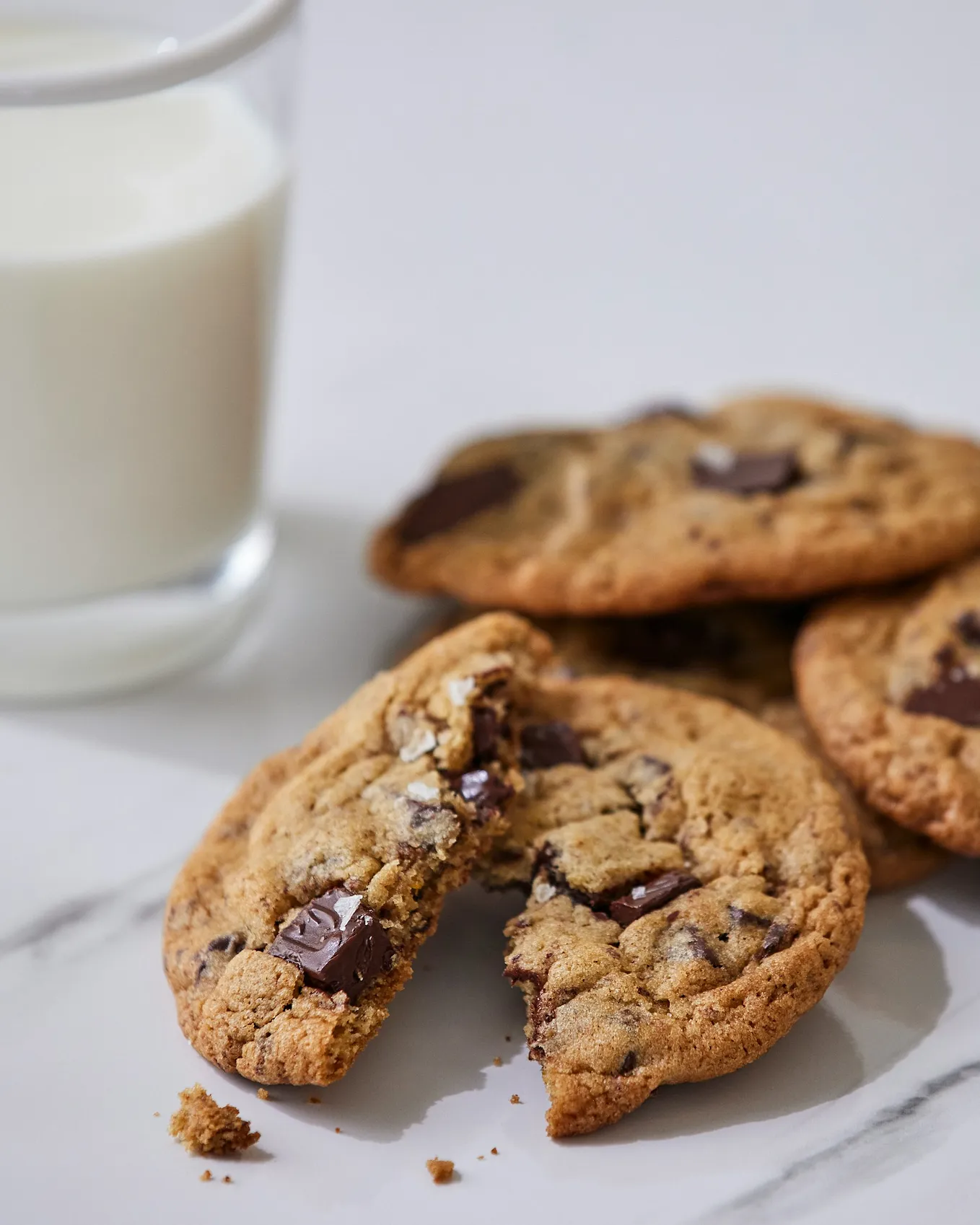 IMAGE: Three chocolate chip cookies in a plate with a glass of milk