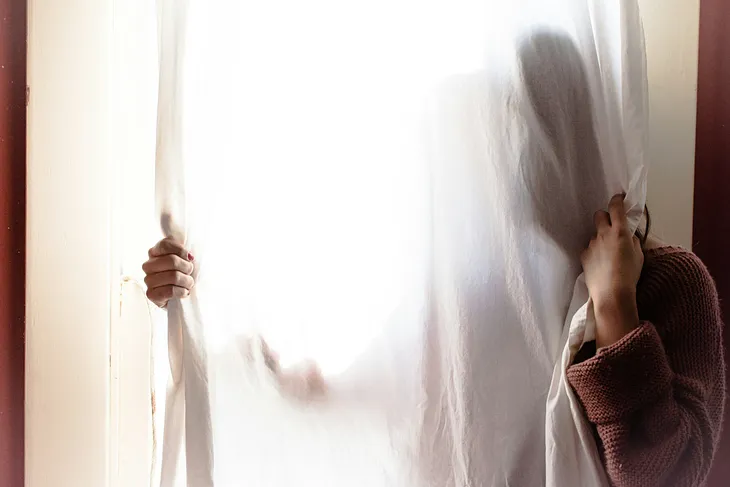 A woman with a curtain covering her face
