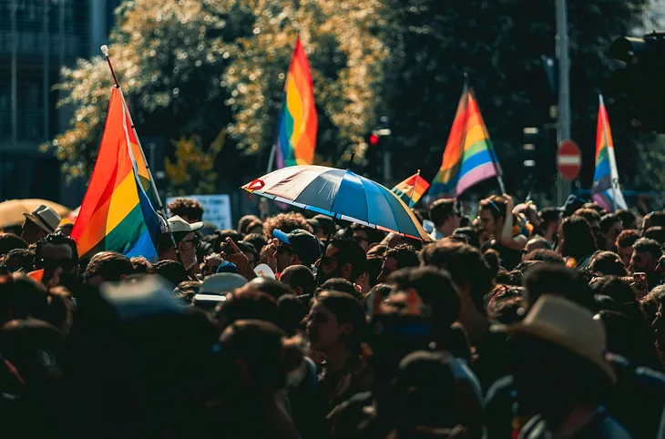 Pride flags stand out in a crowded street