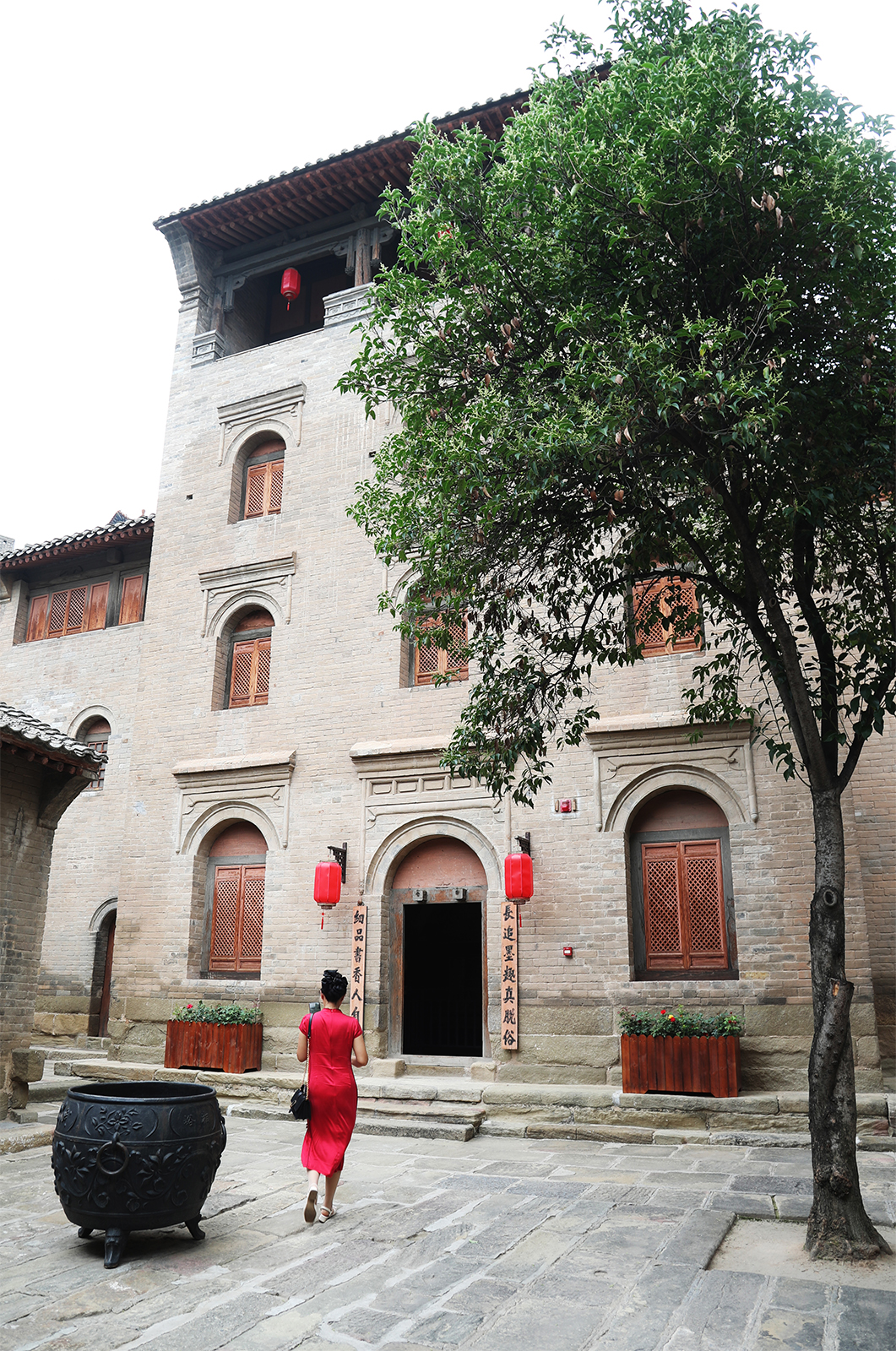 A visitor walks through a courtyard at Xiangyu Ancient Castle. /CGTN