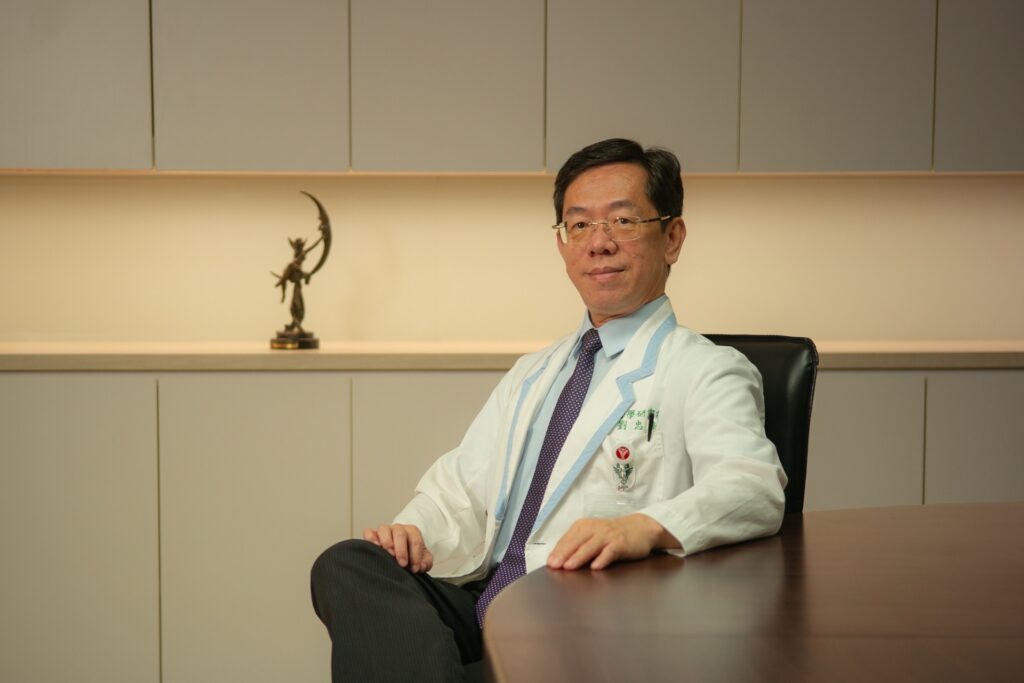 Person in a white lab coat seated at a table