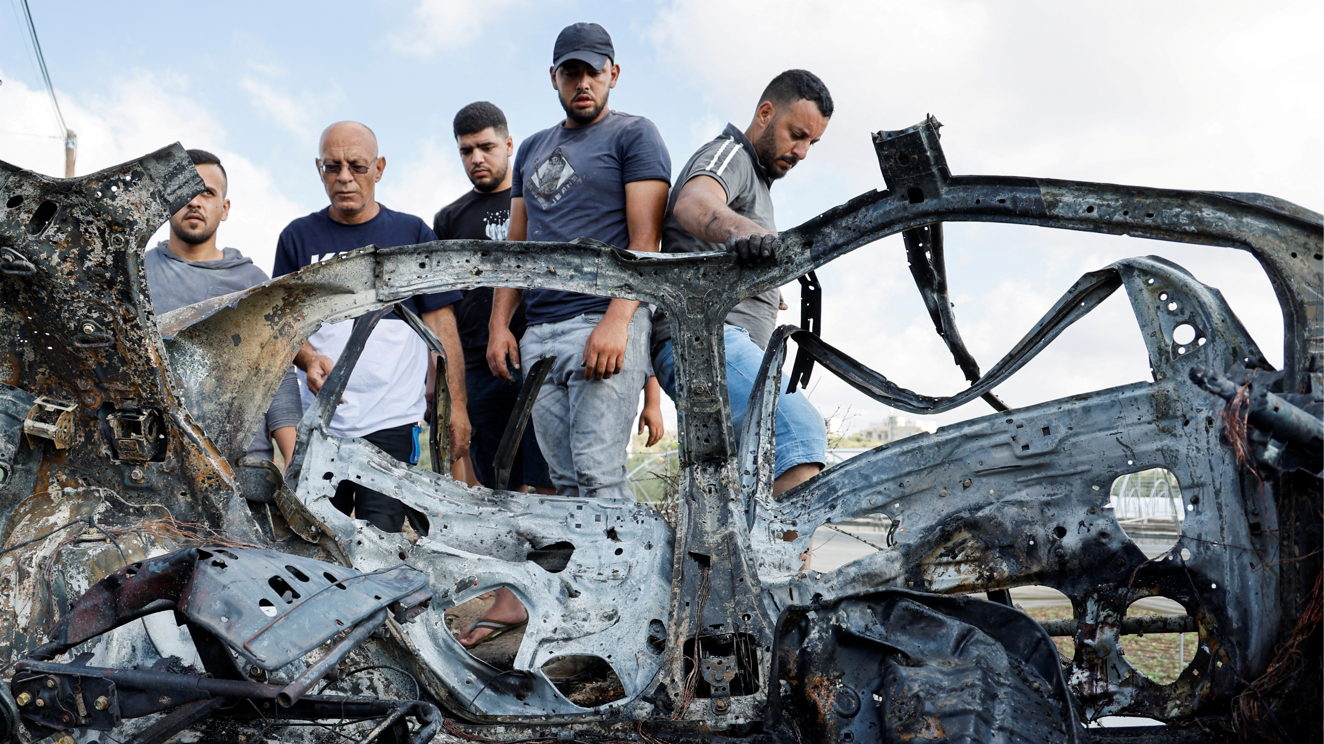 Palestinians inspect a vehicle damaged in an Israeli airstrike, in Zeita, near Tulkarm, in the Israeli-occupied West Bank. /Raneen Sawafta/Reuters