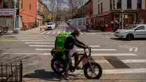 An Uber Eats delivery courier rides an electric bicycle through the Park Slope neighborhood of the Brooklyn borough of New York.