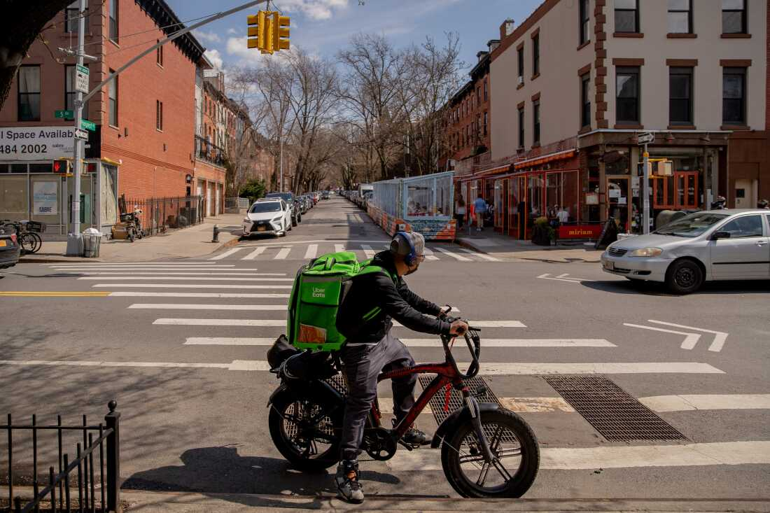 An Uber Eats delivery courier rides an electric bicycle through the Park Slope neighborhood of the Brooklyn borough of New York.