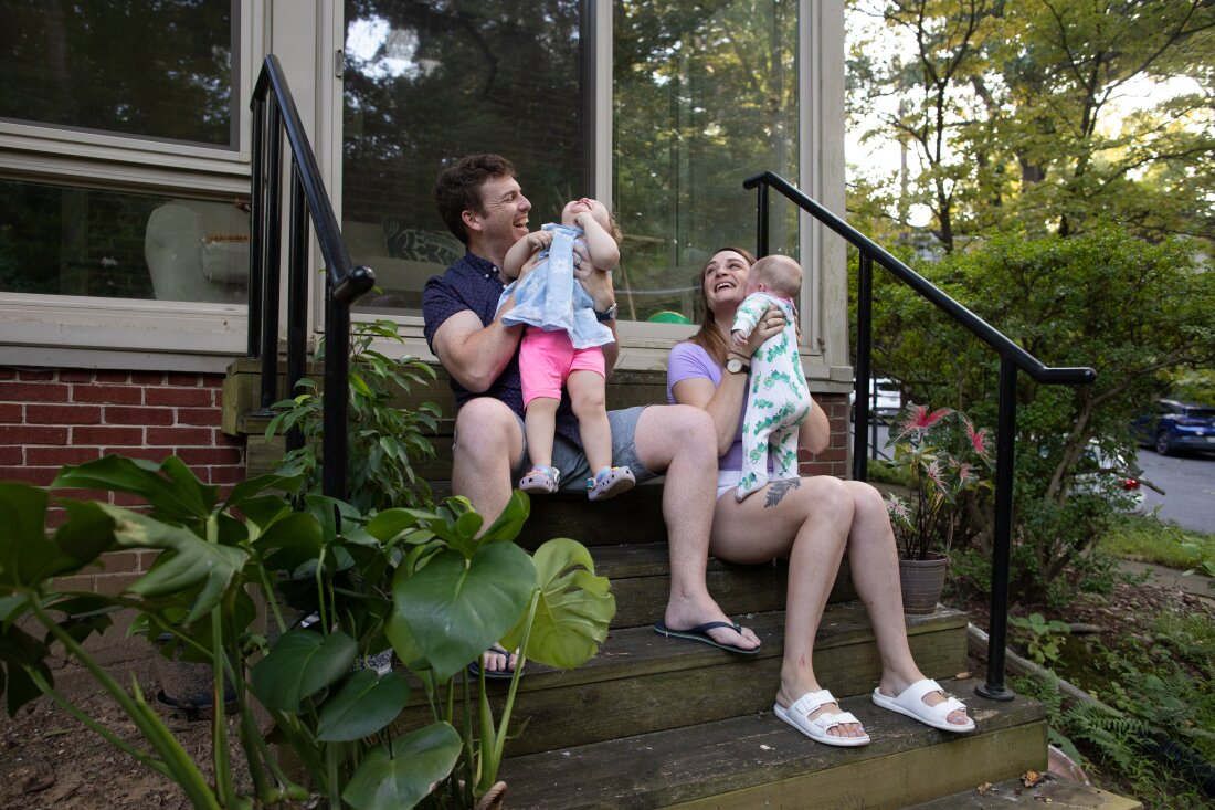 Micaeli and Gerhard du Plessis sit on the steps with their kids. 