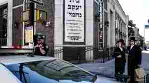 A member of the New York Police Department patrols in front of the synagogue Congregation Bais Yaakov Nechamia Dsatmar on Oct. 13, 2023 in the Williamsburg neighborhood in the borough of Brooklyn in New York City.