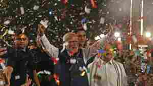 India's Prime Minister Narendra Modi flashes victory signs as he arrives at the Bharatiya Janata Party (BJP) headquarters to celebrate the party's win in the country's general election, in New Delhi, on Tuesday.