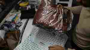 A worker packs a leather jacket in an Amazon India shipping bag at a workshop in the Dharavi area of Mumbai, India, on Jan. 5, 2022.