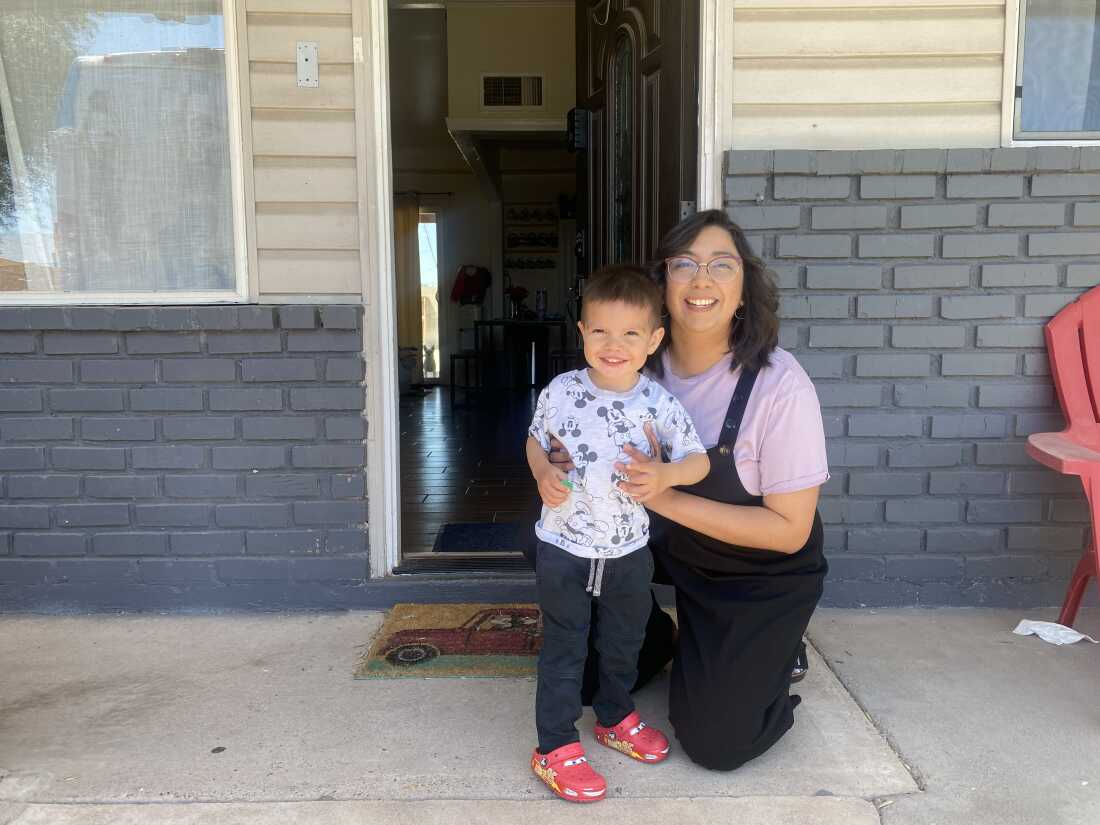 Cynthia Diarte with her 2-year-old son Esteban in front of their home in Phoenix.