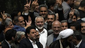 Palestinian Hamas chief Ismail Haniyeh, center, flashes a victory sign as he is surrounded by a group of Iranian lawmakers after the conclusion of the swearing-in ceremony of newly-elected Iranian President Masoud Pezeshkian at the parliament in Tehran, Iran, Tuesday, 30, 2024.