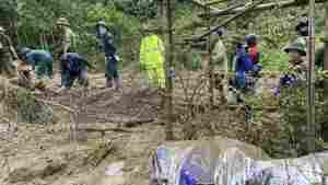 Rescue workers clear mud and debris brought down by a flood in Lang Nu hamlet in Vietnam's Lao Cai province on Tuesday.